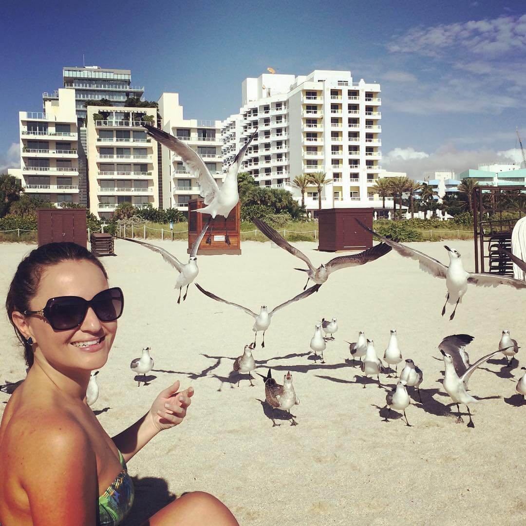 Analu e gaivotas na praia.