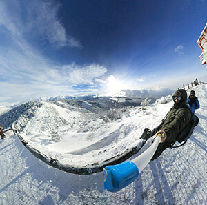 Selfie no Cerro Otto. Céu azul e sol brilhando. Montanhas cheias de neve.