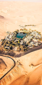 Foto aérea de uma cidade que se localiza no meio de um deserto.