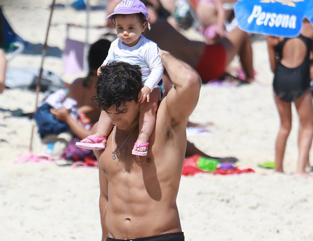 Hugo na praia com sua filha Maria Flor