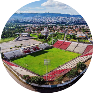 Foto aérea do estádio do time Democráta Futebol CLub. Estádio quadrado, com arquibancadas em tons brancos e vermelhos.