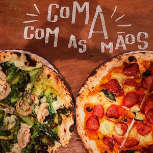 duas pizzas, uma vegetariana e uma de peperone, lado a lado, com a frase "Coma com as mãos" escrita na mesa acima