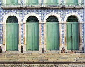 Prédio histórico com portas verde claro e azulejos portugueses.