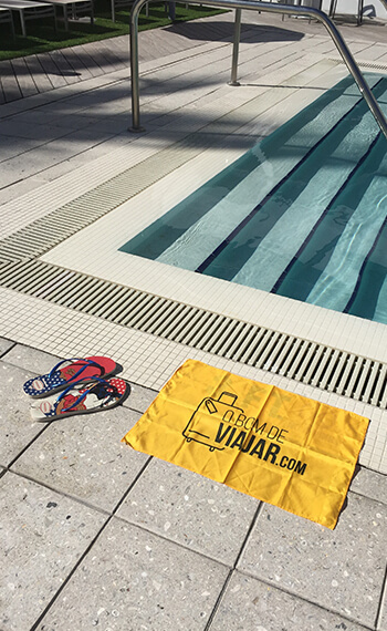 Bandeira do O Bom de Viajar ao lado da piscina do hotel.