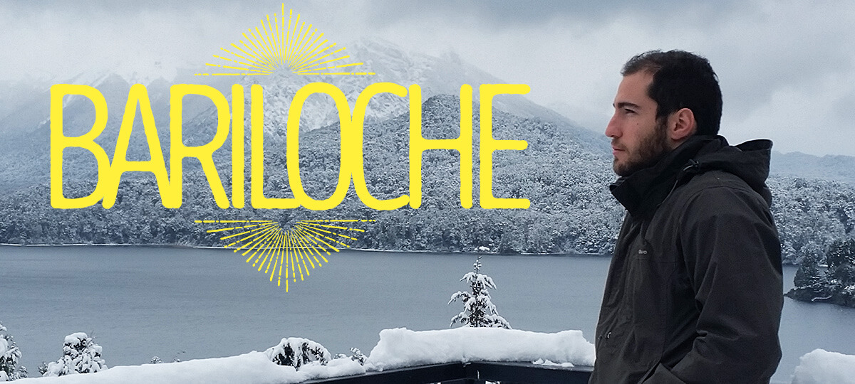 Imagem de abertura do post. Ao fundo, montanhas com neve e um lago. Pepe aparece na foto junto do letreiro "Bariloche".